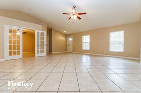 Fort Myers house for rent - A spacious room with a ceiling fan and tiled flooring.