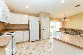 Fort Myers house for rent - A kitchen with a white refrigerator and cabinets.