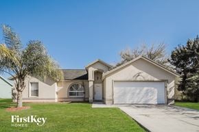 Kissimmee house for rent - A house with a garage and a tree in front of it.