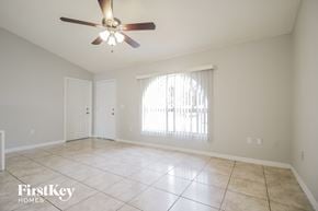 Kissimmee house for rent - A spacious room with a ceiling fan and tiled flooring.