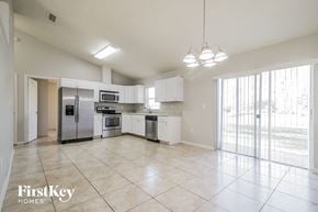 Kissimmee house for rent - A spacious kitchen with white appliances and cabinets.