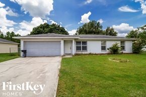 Kissimmee house for rent - A white house with a garage door is for sale by FirstKey Homes.