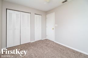 Kissimmee house for rent - A bedroom with white closet doors and a carpeted floor.