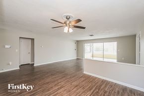 Palm Harbor house for rent - A spacious room with a ceiling fan and wooden flooring.