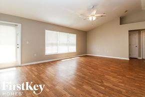 Lehigh Acres house for rent - A spacious room with wooden floors and a ceiling fan.