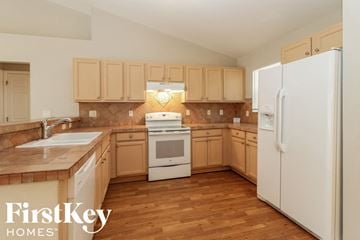 Lehigh Acres house for rent - A kitchen with wooden cabinets and a white fridge.