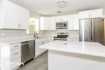 Palm Beach Gardens house for rent - a white kitchen with stainless steel appliances and white counter tops