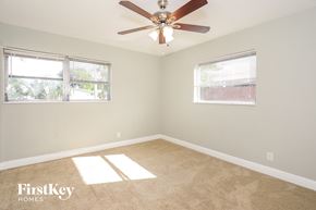 Palm Beach Gardens house for rent - a bedroom with a ceiling fan and two windows