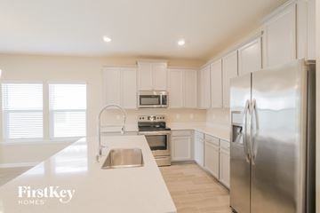 St. Augustine house for rent - a kitchen with white cabinets and stainless steel appliances