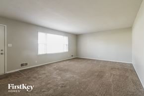 Plainfield house for rent - an empty living room with carpet and a window