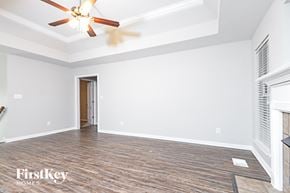 Odenville house for rent - a empty living room with white walls and a ceiling fan