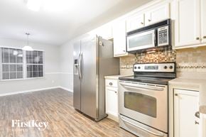 Odenville house for rent - a kitchen with stainless steel appliances and white cabinets