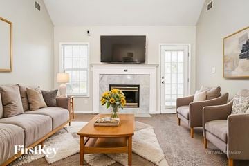 Fayetteville house for rent - A living room with a fireplace and a television mounted above it.