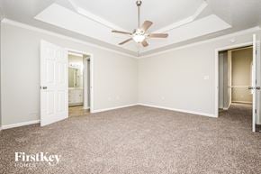Fayetteville house for rent - A spacious room with a ceiling fan and carpeted floor.