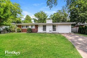 Florissant house for rent - a small white and brick house with a grassy yard