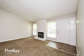Florissant house for rent - a living room with a fireplace and a white door