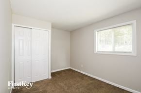 Florissant house for rent - a bedroom with carpet and a white door and a window