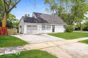Park Forest house for rent - a small white house with a garage and a driveway