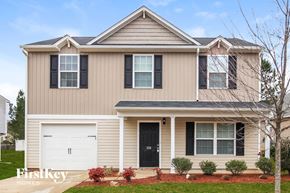 Clayton house for rent - a tan house with black shutters and a white garage door
