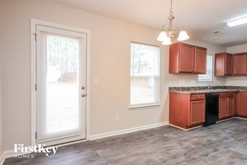 Clayton house for rent - a kitchen with wooden cabinets and a door leading into a window