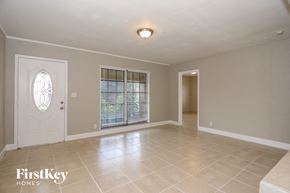 Oakland Park house for rent - A spacious room with a door and a window with blinds.