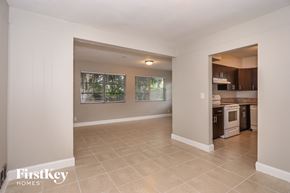 Oakland Park house for rent - A spacious room with a kitchen area visible through the doorway.