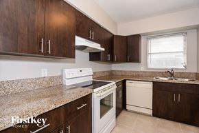 Oakland Park house for rent - A kitchen with brown cabinets and a granite countertop.