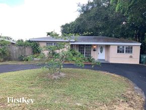 Oakland Park house for rent - A house with a white door and a small tree in front.