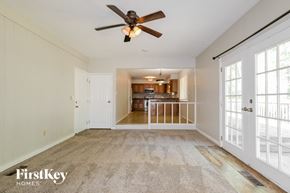 Saint Charles house for rent - an empty living room with a ceiling fan and a kitchen