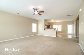 Winston-Salem house for rent - A spacious room with a ceiling fan and carpeted floor.