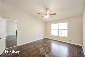 Covington house for rent - the spacious living room with hardwood flooring and a ceiling fan