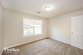 Covington house for rent - a bedroom with carpet and a window and a white door