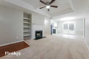 Senoia house for rent - an empty living room with a fireplace and a ceiling fan
