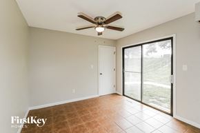 Blue Springs house for rent - a living room with a ceiling fan and a sliding glass door