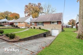 Cincinnati house for rent - a brick house with a white garage and a sidewalk