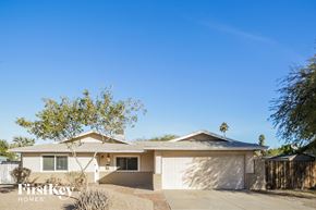 Tempe house for rent - A house with a garage and a tree in front of it.