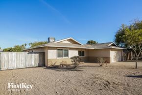 Tempe house for rent - A house with a brown roof and a white fence is shown in the image.