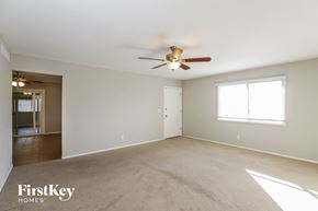Tempe house for rent - A spacious room with a ceiling fan and a carpeted floor.