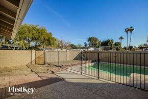 Tempe house for rent - A pool surrounded by a black fence with the words "FirstKey Homes" on the bottom left.