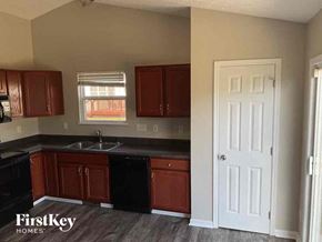 Trenton house for rent - A kitchen with dark brown cabinets and a black counter top.