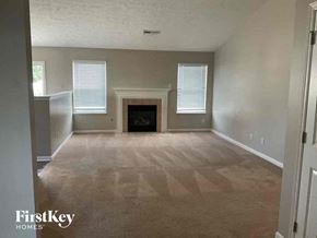 Trenton house for rent - A spacious living room with a fireplace and a carpeted floor.