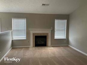 Trenton house for rent - A living room with a fireplace and two windows.