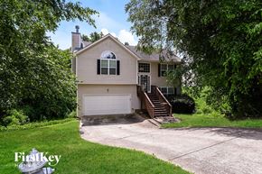 Canton house for rent - A house with a garage is surrounded by trees.