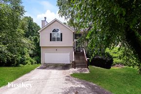 Canton house for rent - A house with a garage and a driveway is surrounded by trees.