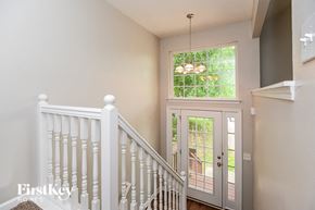 Canton house for rent - A staircase with a white railing leads to a door with a glass window.