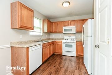 Canton house for rent - A kitchen with wooden cabinets and white appliances.