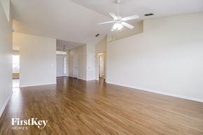 Poinciana house for rent - a spacious living room with hardwood floors and a ceiling fan