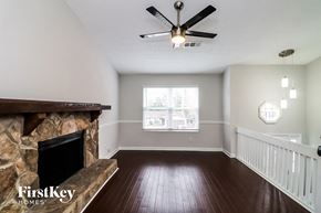 Roswell house for rent - a living room with a fireplace and a ceiling fan