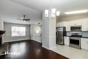 Roswell house for rent - a kitchen with white cabinets and stainless steel appliances