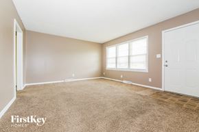 Blue Springs house for rent - A room with a carpeted floor and a white door.